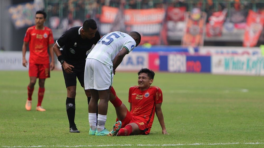Gelandang Persija, Syahrian Abimanyu dapat pertolongan dari pemain tengah Persib, Levy Madinda pada laga pekan ke-11 Liga 1 2023-2024, 2 September 2023. (Mario Sonatha untuk Skor.id)