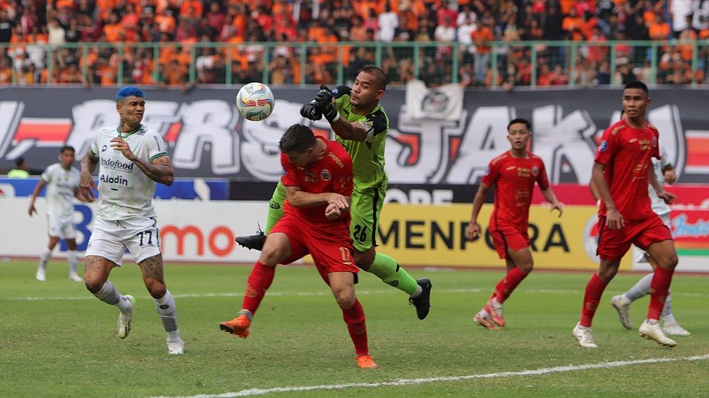 Aksi kiper Persija, Andritany (tengah) yang berjibaku dengan Firza Andika saat selamatkan bola hasil sepakan pemain Persib, Ciro Alves pada laga pekan ke-11 Liga 1 2023-2024, 2 September 2023. (Mario Sonatha untuk Skor.id)