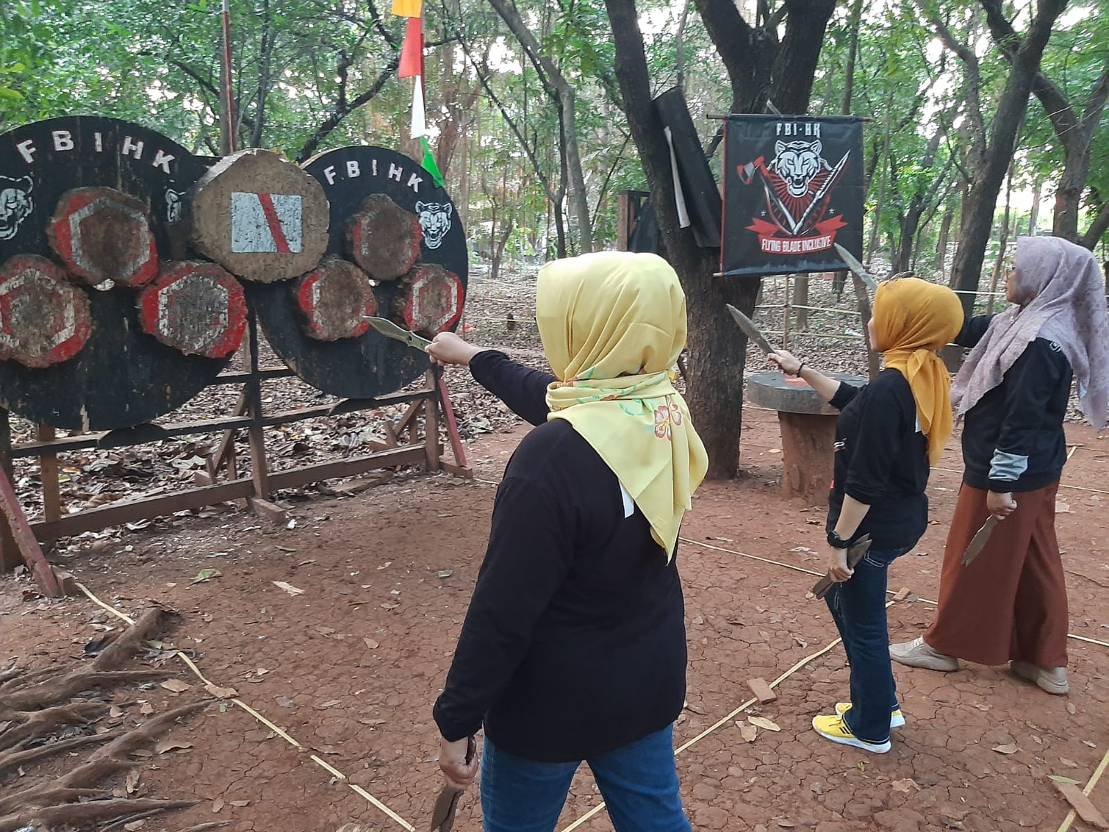 Beberapa anggota wanita Flying Blade Inclusive (FBI), klub lempar pisau dan kapak yang berada di bawah naungan PB Porlempika, tampak berlatih di Hutan Taman Kota, Bekasi, Jawa Barat. (Dok. FBI - Rahmat Ari Hidayat/Skor.id) 