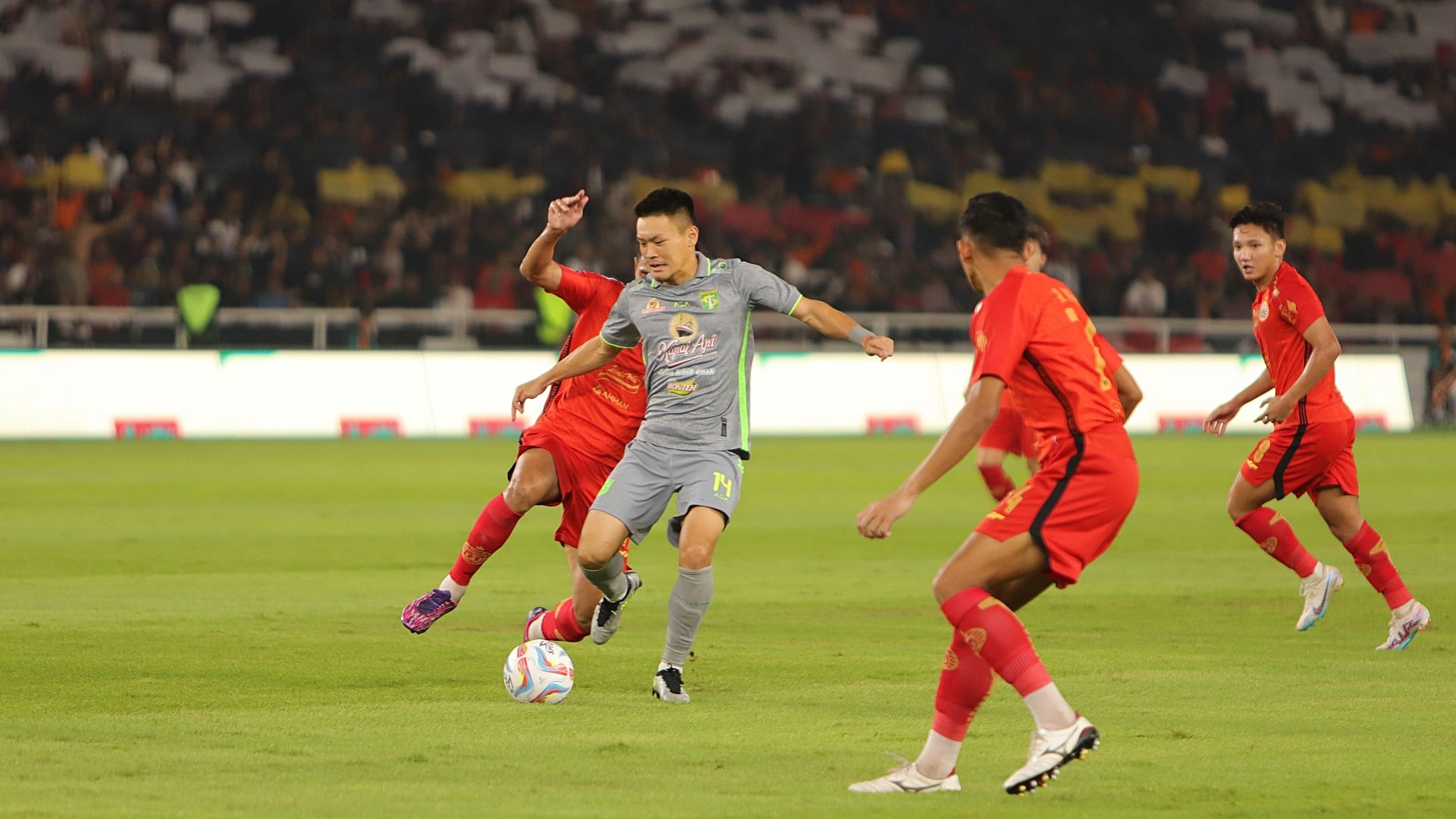 Aksi Sho Yamamoto dari Persebaya di antara beberapa pemain Persija dalam laga pekan kelima Liga 1 2023-2024, 30 Agustus 2023. (Mario Sonatha untuk Skor.id)