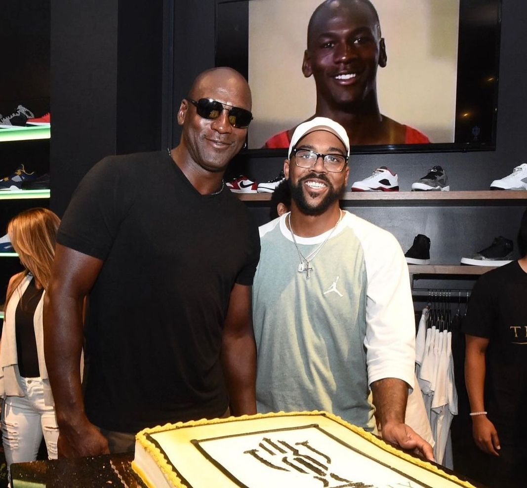 Marcus Jordan dan ayahnya, legenda NBA Michael Jordan, berpose di depan kue raksasa saat HUT Throphy Room ke-6 pada Mei 2022 (Dok. Instagram @heirmj523).