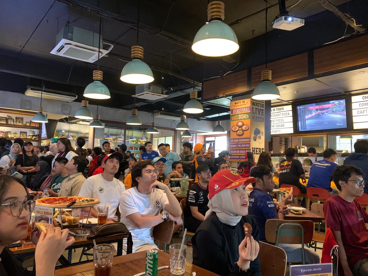 Fans F1 Indonesia bersama-sama menyaksikan keseruan balapan GP Las Vegas 2024 dalam acara nobar di Pizza E Birra, Cilandak Town Square, Jakarta, Minggu (24/11/2024). (Arin/Skor.id)