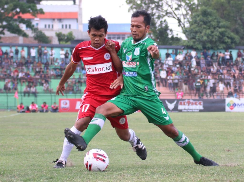 Pemain AA Tiga Naga (kiri) berebut bola dengan pemain PSMS Medan dalam pertandingan pekan pertama Liga 1 2020 di Stadion Teladan, Medan pada 15 Maret 2020.