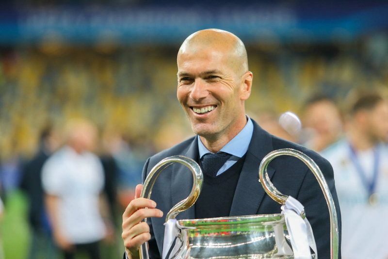 Zinedine Zidane memegang trofi Liga Champions yang direbutnya bersama Real Madrid.