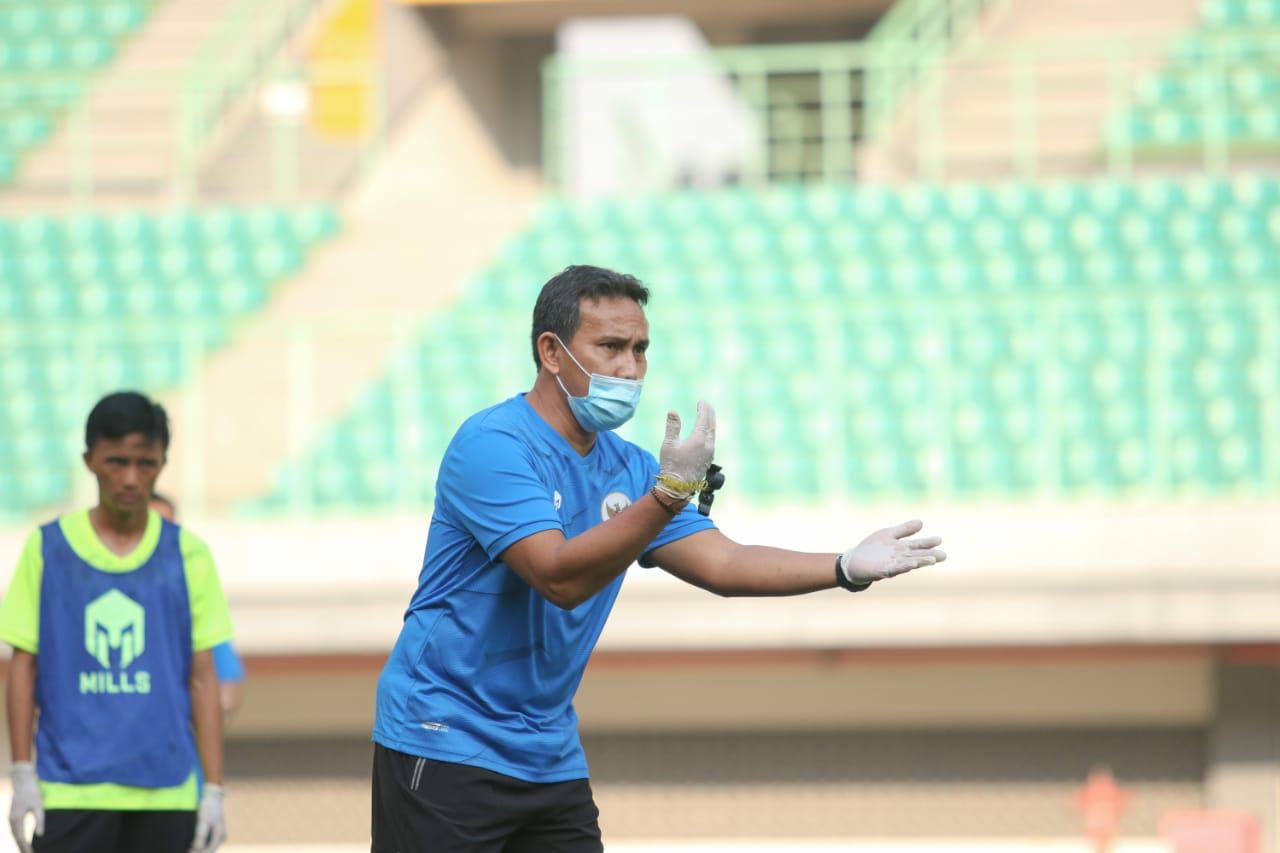 Pelatih timnas Indonesia U-16, Bima Sakti, memakai masker saat memimpin TC anak asuhnya di Stadion Patriot Candrabhaga, Senin (6/7/2020).