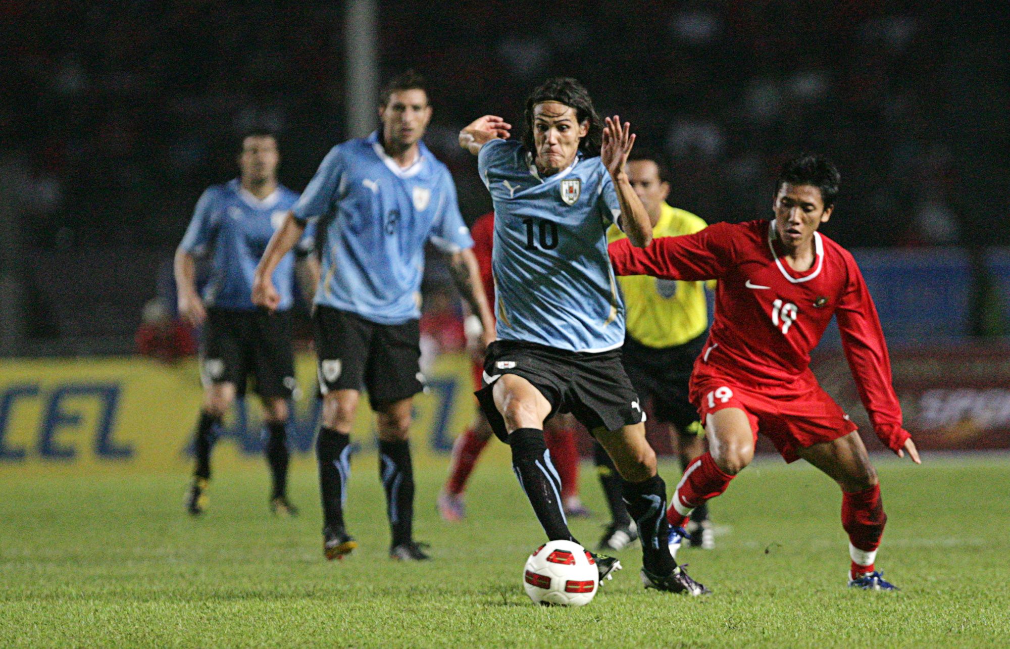 Edinson Cavani (depan), pemain timnas Uruguay, melewati adangan Ahmad Bustomi dalam pertandingan uji coba di Stadion Utama Gelora Bung Karno, Senayan, Jakarta pada 2010.