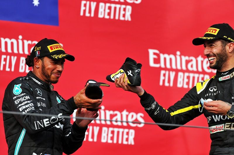 Pembalap Renault, Daniel Ricciardo (kanan), mengajak pembalap Mercedes-AMG Petronas, Lewis Hamilton (kiri), untuk bersulang dan minum sampanye dari sepatu alias shoey dalam perayaan podium F1 GP Emilia Romagna yang digelar di Sirkuit Imola, Italia, pada Minggu (1/11/2020).