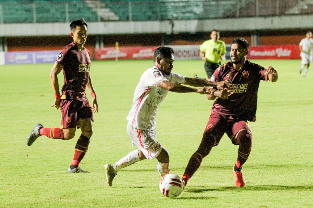 Gelandang Persija, Ramdani Lestaluhu coba dihentikan bek tengah PSM Makassar, Hasim Kipuw (kanan) dan disaksikan Sutanto Tan dalam leg pertama semifinal Piala Menpora 2021 di Stadion Maguwoharjo, Kabupaten Sleman, 15 April 2021.