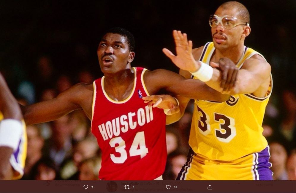 Center Houston Rockets Hakeem Olajuwon (kiri) coba ditahan center LA Lakers Kareem Abdul-Jabbar dalam pertandingan NBA pada tahun 1989.