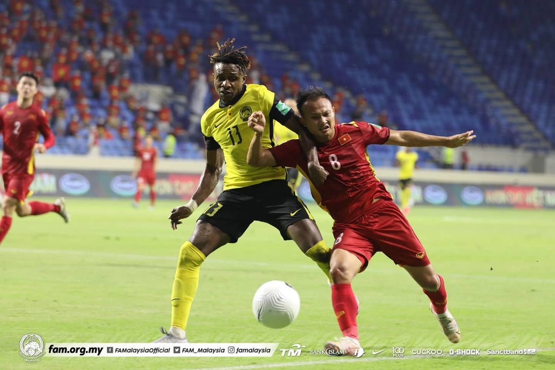 Pemain timnas Malaysia, Mohamadou Sumareh, mengawal pergerakan gelandang Vietnam, Nguyen Trong Hoang, dalam lanjutan Grup G Kualifikasi Piala Dunia 2022, Jumat (11/6/2021).