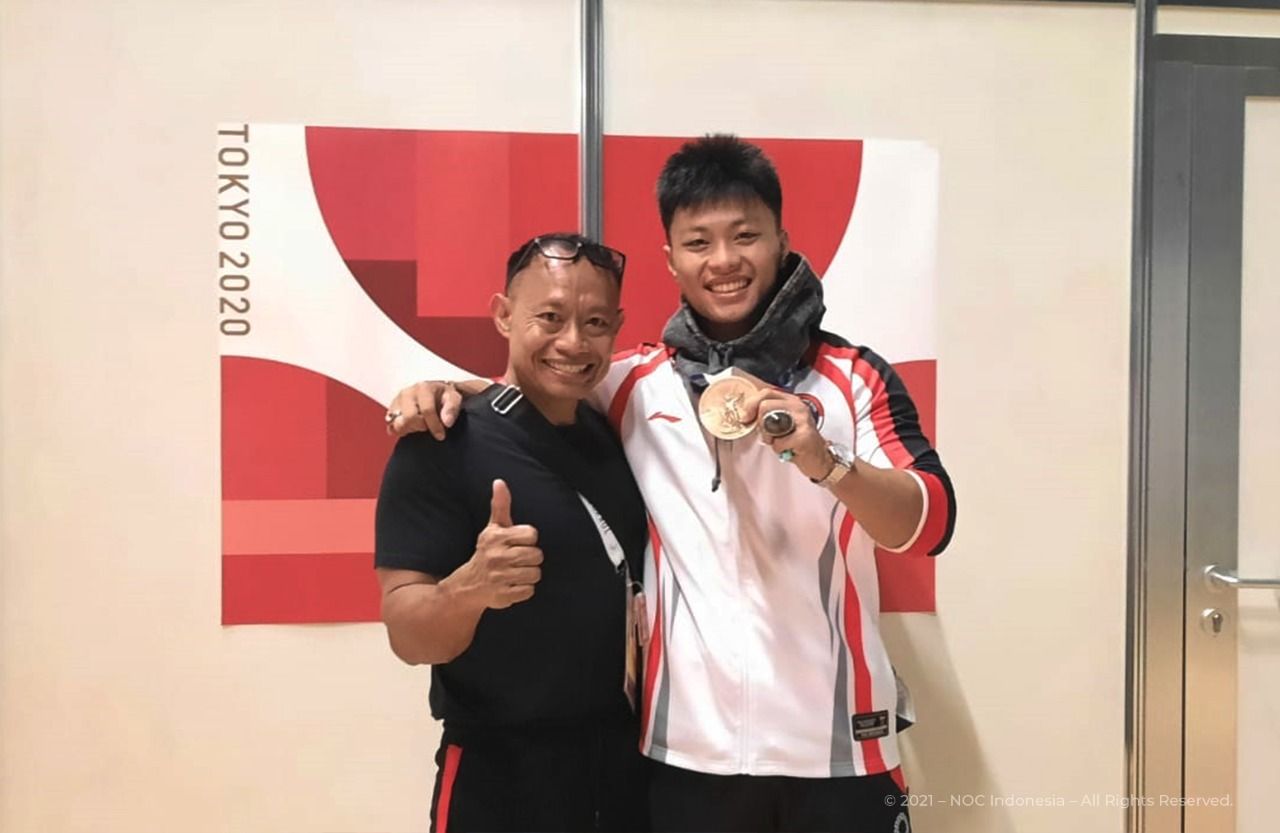 Erwin Abdullah bersama sang putra, Rahmat Erwin Abdullah, setelah meraih medali perunggu angkat besi kelas 73kg Olimpiade Tokyo.