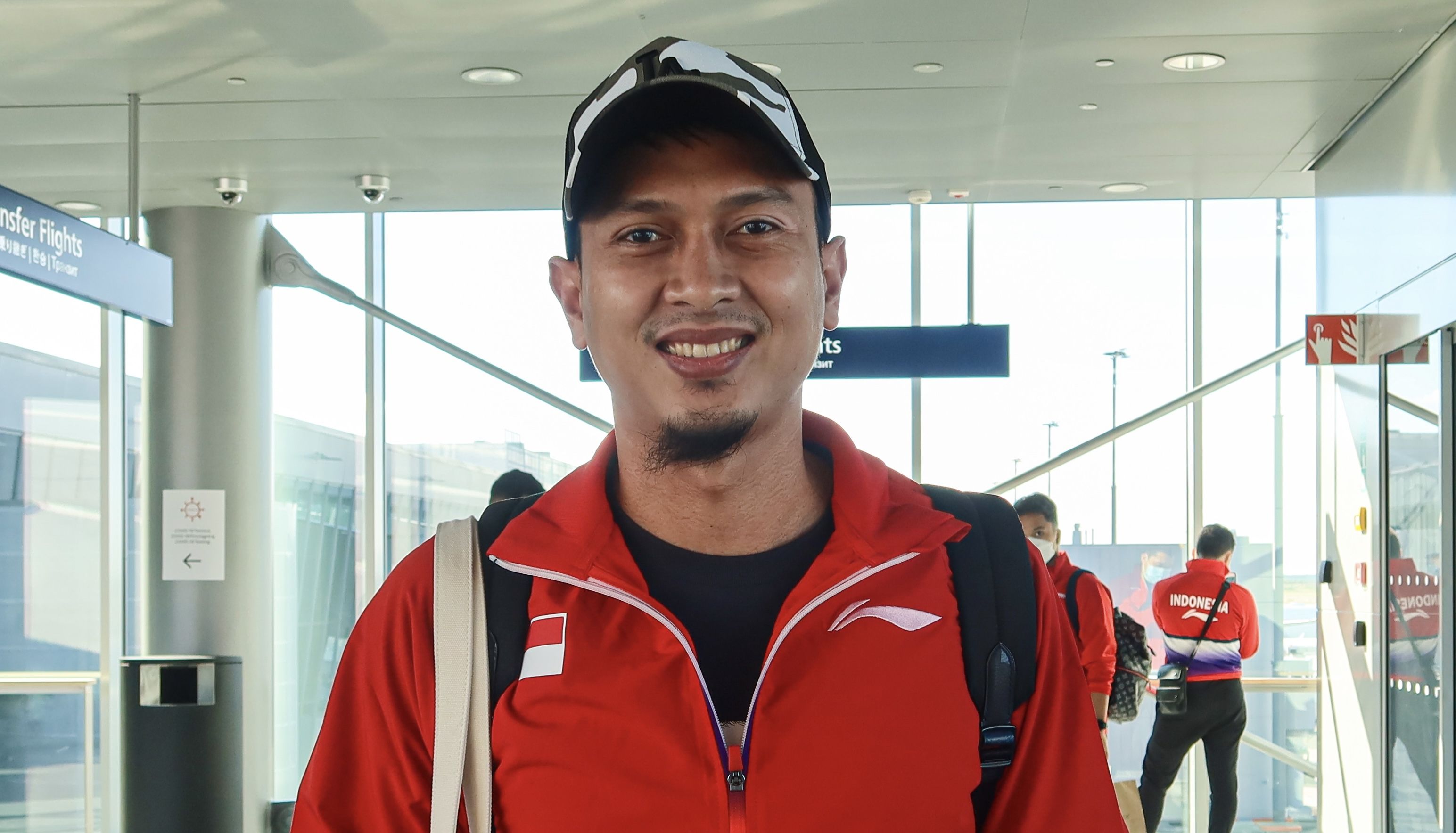 Mohammad Ahsan tersenyum saat tiba di Bandara Helsinski, Finlandia. Tim Sudirman Cup Indonesia sempat berada dalam situasi tegang karena pesawat mereka gagal mendarat