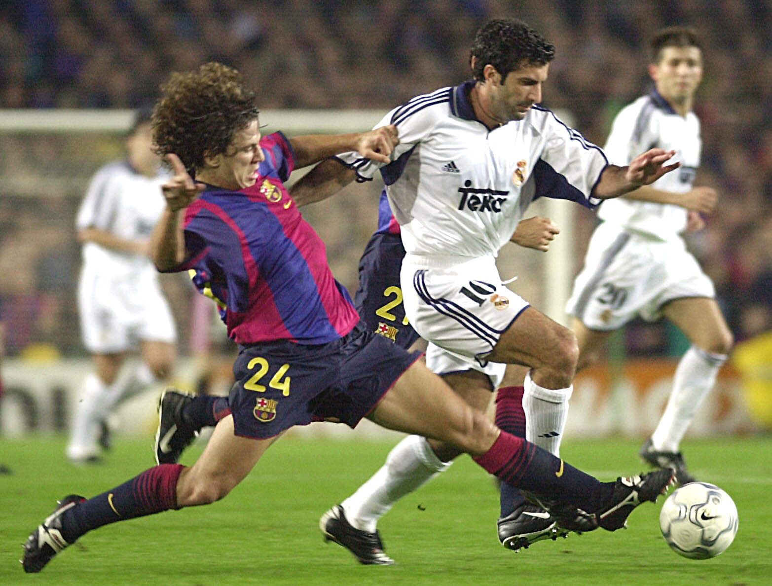 Carles Puyol (kiri) saat berduel menghentikan bintang Real Madrid, Luis Figo.