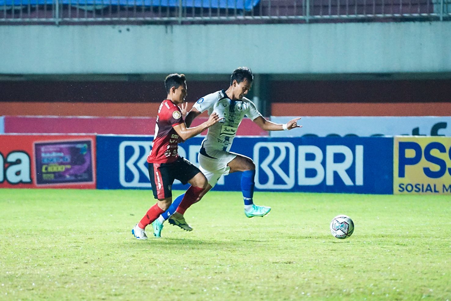 Penyerang PSIS Semarang, Hari Nur Yulianto (kanan), dikawal bek Bali United, Dias Angga Putra (kiri) pada laga pekan kesepuluh Liga 1 2021-2022 di Stadion Maguwoharjo, Sleman, Minggu (31/10/2021).