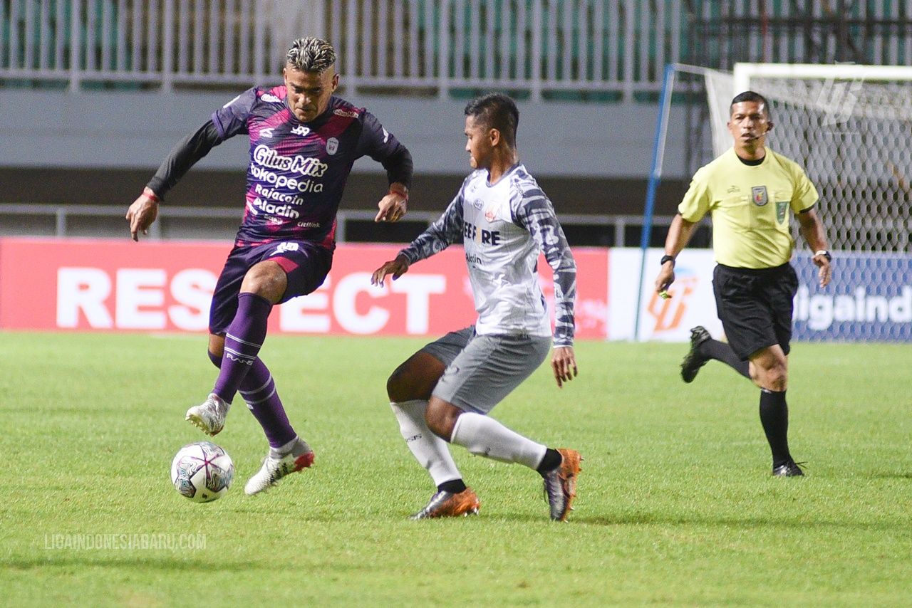 Penyerang Rans Cilegon FC, Cristian Gonzales (kiri), berduel dengan bek Persis Solo, Ganjar Mukti (tengah), pada partai pertama babak 8 besar Liga 2 2021, Rabu (15/12/2021).