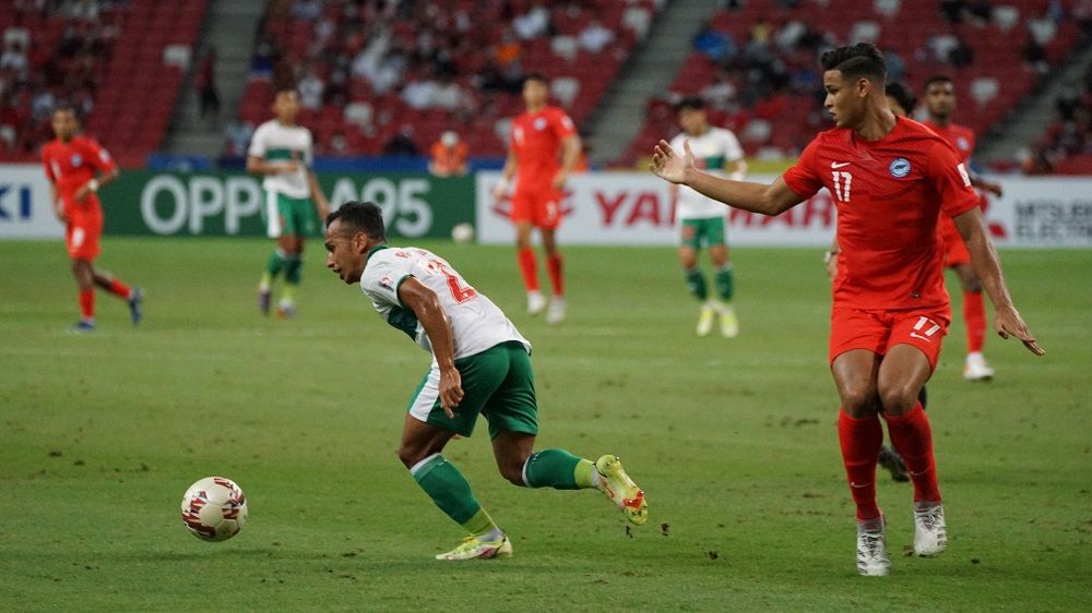 Pergerakan pemain Indonesia, Irfan Jaya hanya dilihat bek Singapura, Irfan Fandi dalam laga leg pertama semifinal Piala AFF 2020, 22 Desember 2021.