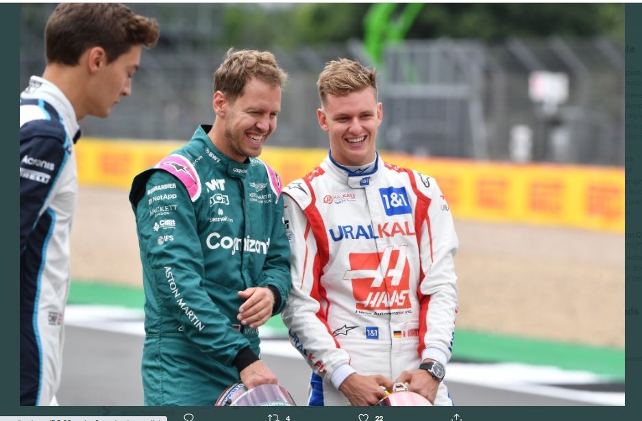 Sebastian Vettel dan Mick Schumacher berinteraksi saat melihat prototipe mobil baru F1 2022 yang pertama kali ditunjukkan ke publik di Sirkuit Silverstone, Inggris.