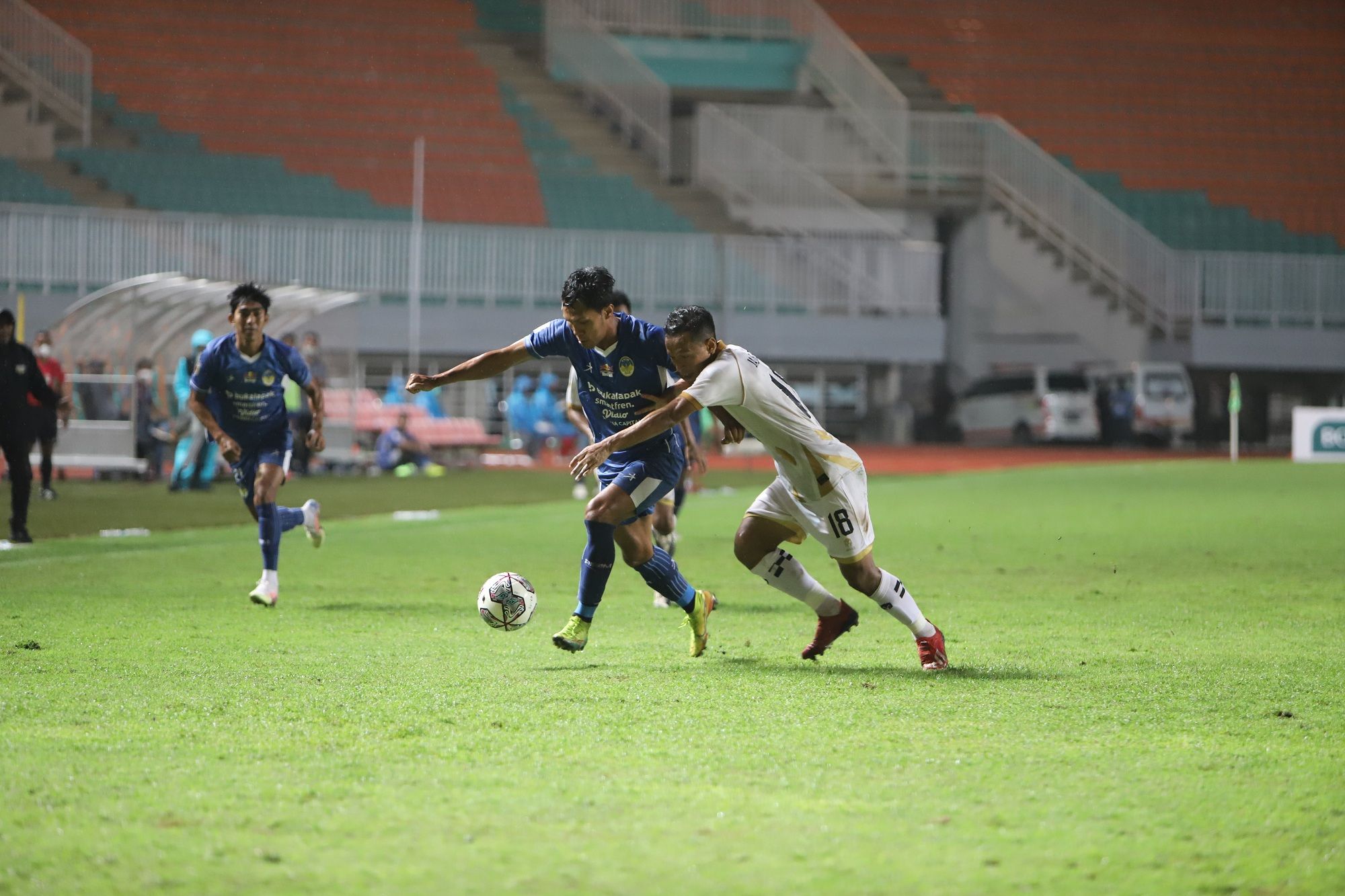 Bek sayap Dewa United FC, Jajang Sukmara (putih), coba merebut bola dari penguasaan pemain PSIM Yogyakarta pada laga perebutan peringkat ketiga Liga 2 2021 di Stadion Pakansari, Bogor, 30 Desember 2021.