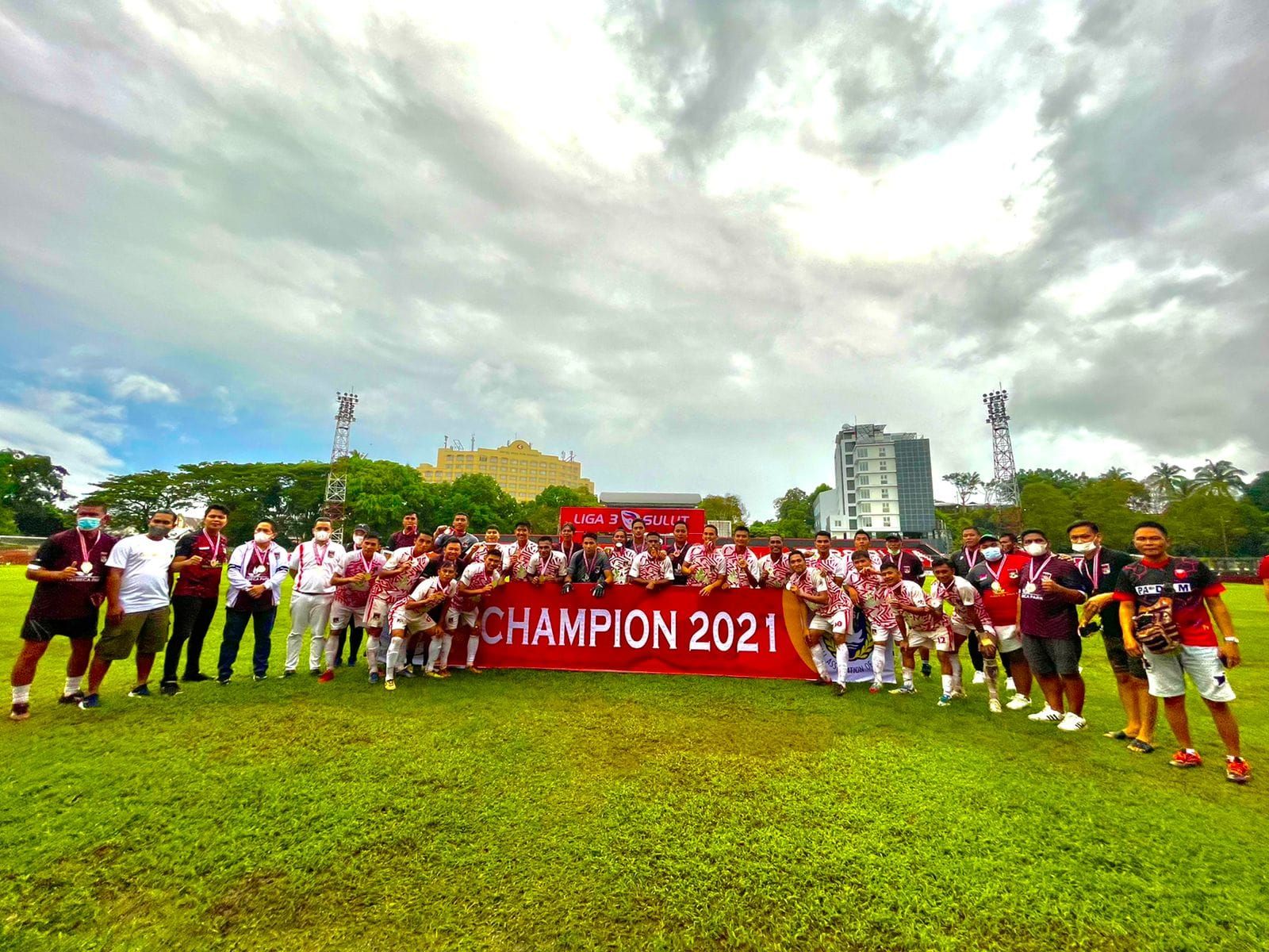Para pemain, ofisial, pelatih, serta dari manajemen Persmin Minahasa merayakan sukses timnya mengalahkan Tahuna FC untuk menjuarai Liga 3 Sulawesi Utara 2021 di Stadion Klabat, Kota Manado, 30 Desember 2021.
