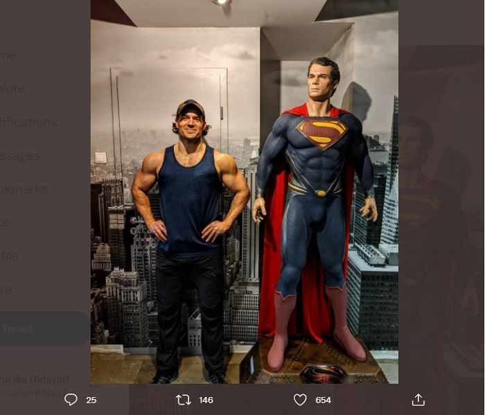 Henry Cavill berdiri di sebelah sosok superhero yang diperankannya Superman pada tahun 2019.