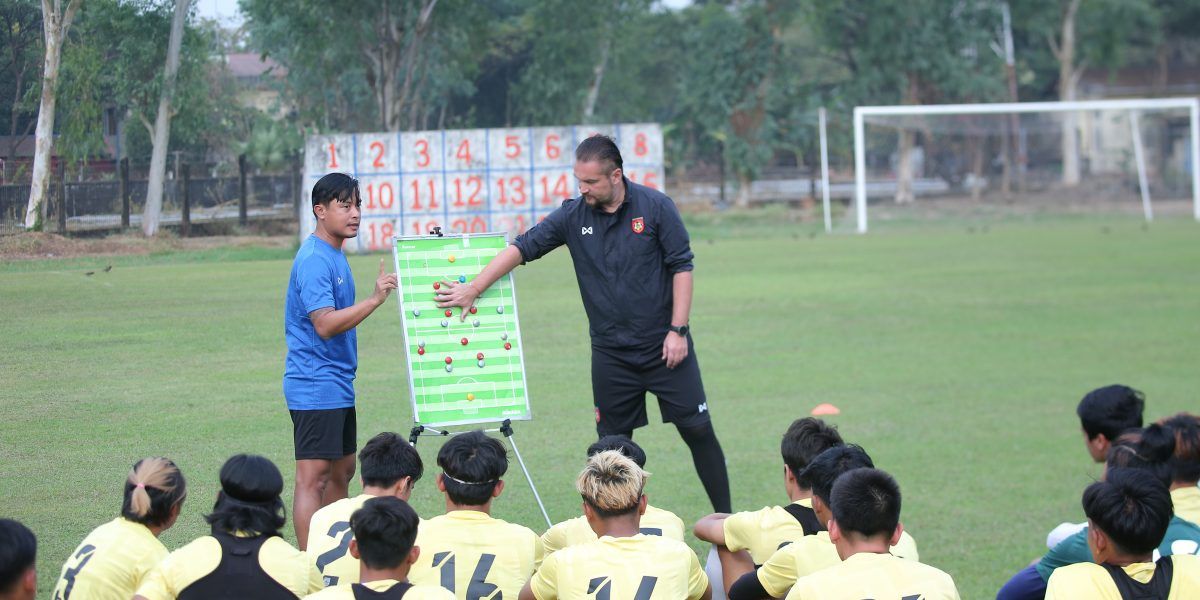 Pelatih asal Bulgaria, Velizar Popov (kaos hitam) memberikan instruksi ke pemain timnas Myanmar dengan bantuan penerjemahnya dalam latihan  pada Januari 2022.
