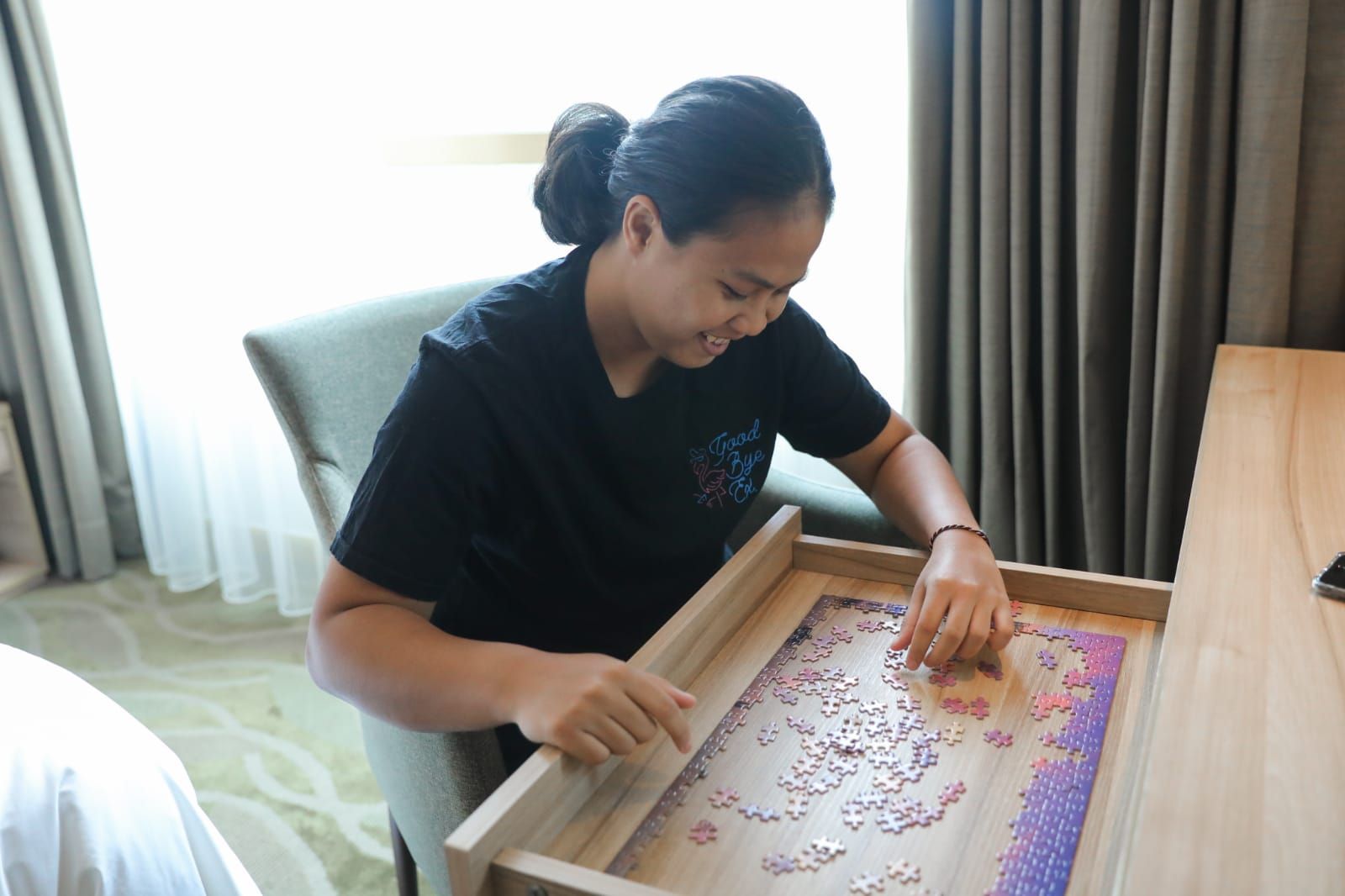 Jesita Putri Miantoro mengisi waktu karantina dengan menyusun puzzle di kamar.