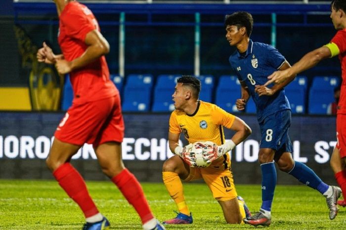 Kiper Singapura, Ridhwan Fikri Aban di antara rekan setim dan pilar Thailand dalam laga pertama Grup C penyisihan Piala AFF U-23 2022 di Kamboja, 16 Februari 2022.