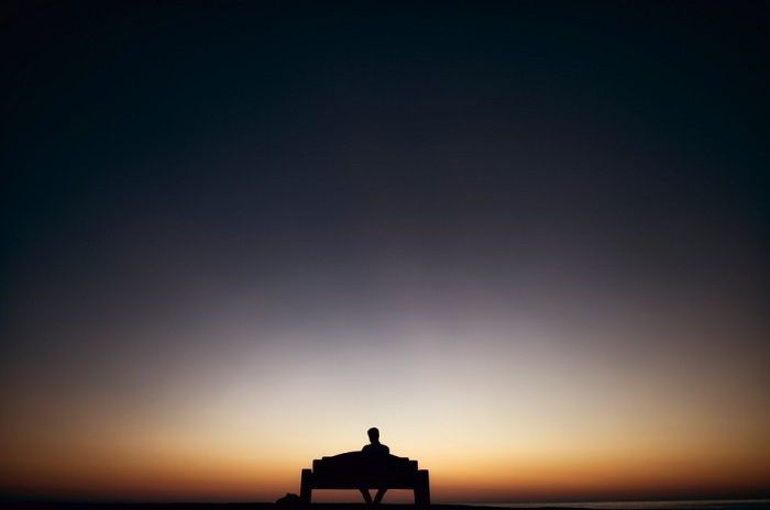 Ilustrasi seorang lelaki duduk sendirian.