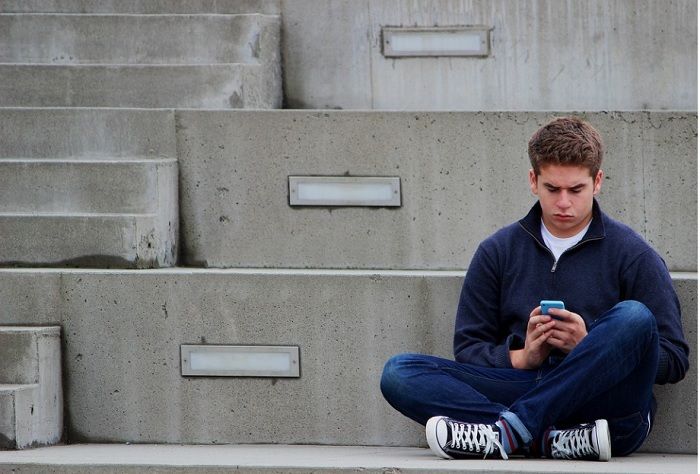 Ilustrasi seorang remaja lelaki duduk seorang diri.