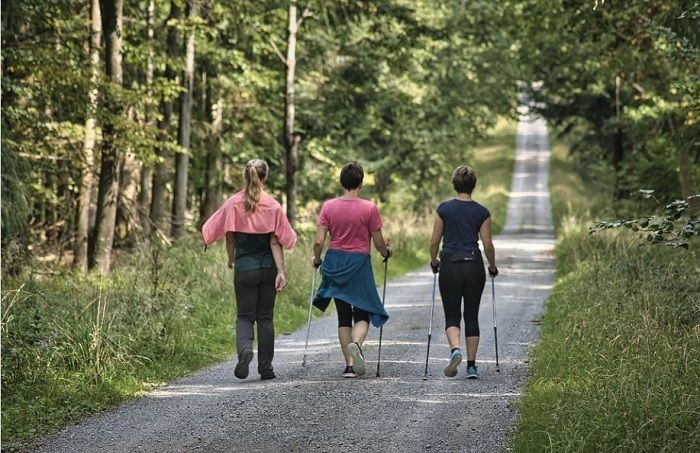 Ilustrasi tiga wanita melakukan aktivitas fisik berjalan kaki.