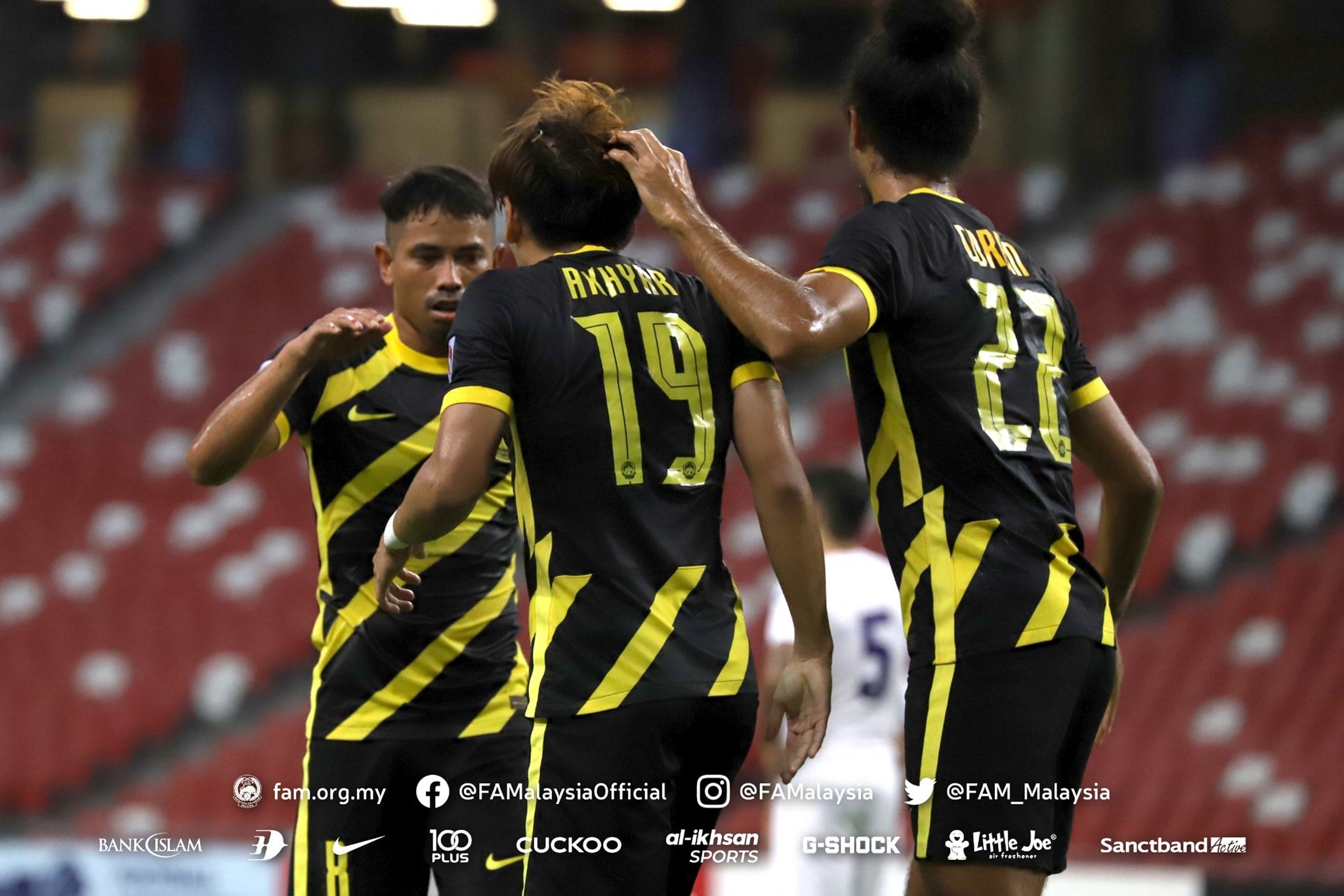 Akhyar Rashid (tengah) diapit duo rekannya, Safiq Rahim dan La'Vere Corbin-Ong seusai membuat gol bagi timnas Malaysia ke gawang Filipina dalam laga uji coba di SIngapura pada 23 Maret 2022.