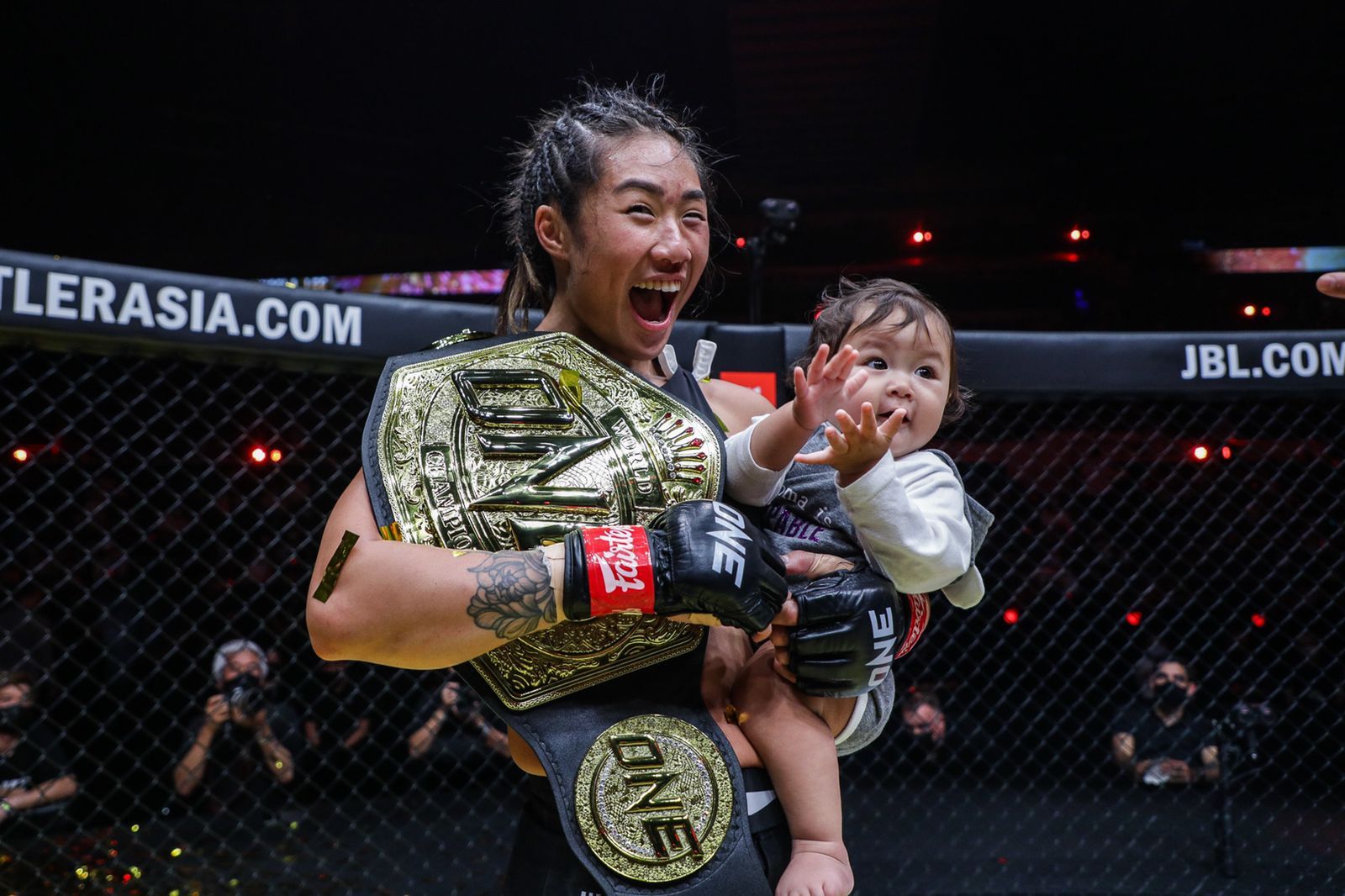 Petarung ONE Championship, Angela Lee, meluapkan kegembiraan bersama putri kecilnya usai mempertahankan gelar juara dunia dalam ONE X, Sabtu (26/3/2022).