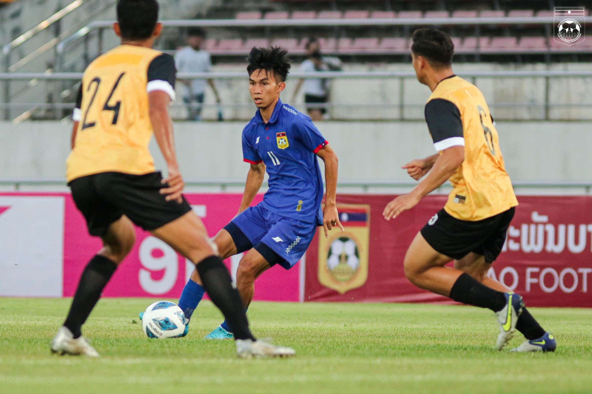 Pemain timnas Laos dijaga dua pilar Brunei Darussalam dalam uji coba internasional pada 27 Maret 2022.
