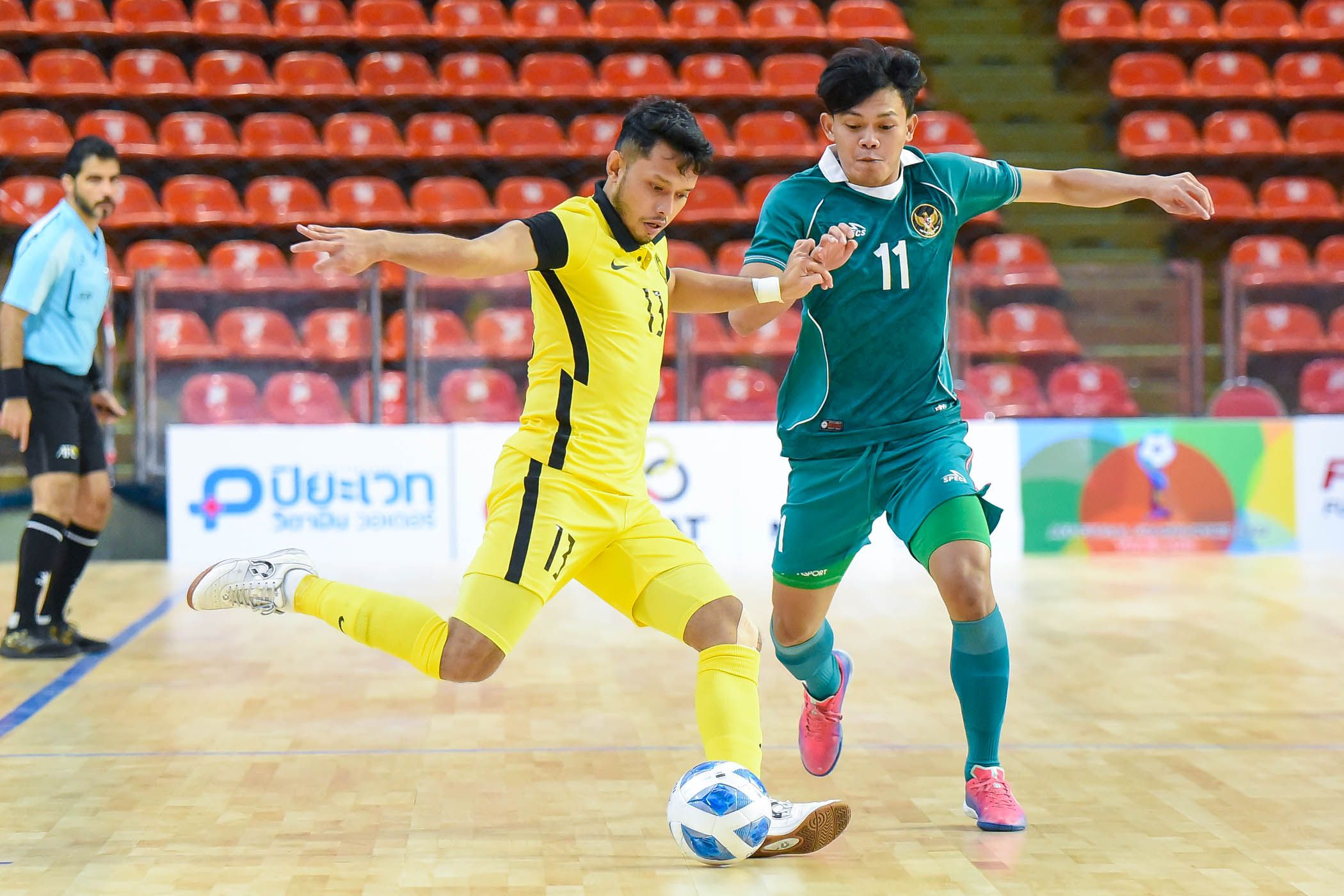Flank timnas futsal Indonesia, Firman Adriansya (hijau), mencoba merebut bola dari lawan dalam laga melawan Malaysia pada fase grup Piala AFF Futsal 2022 di Stadion Huamark Indoor, Bangkok, Thailand, 4 April 2022.