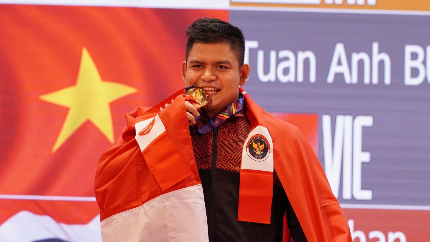 Muhammad Zul Ilmi berpose usai meraih medali emas angkat besi kelas 89 kg putra SEA Games 2021 di Hanoi Sports and Training Centre, Minggu (22/5/2022). 