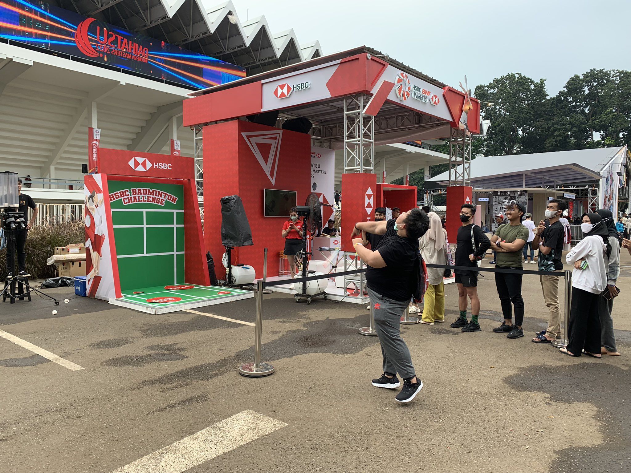 Pengunjung sedang mencoba permainan di booth HSBC yang meramaikan Indonesia Masters 2022.