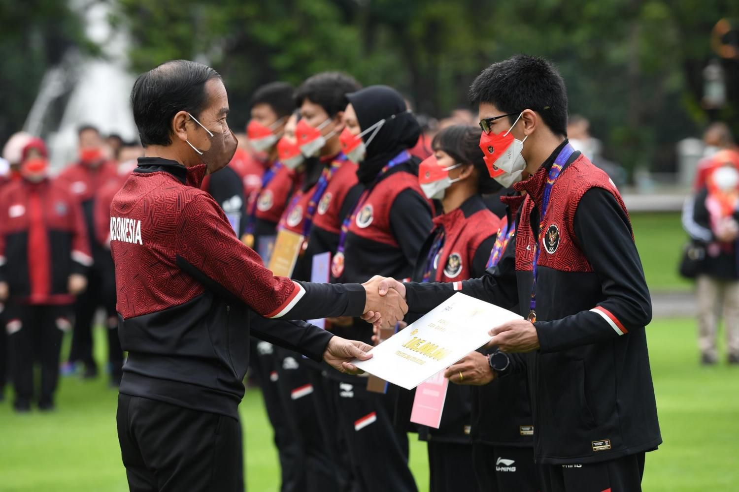 Presiden RI Joko Widodo (kiri) memberikan bonus secara simbolis kepada atlet peraih medali SEA Games 2021 di Istana Bogor, Jawa Barat, Senin (13/6/2022). 