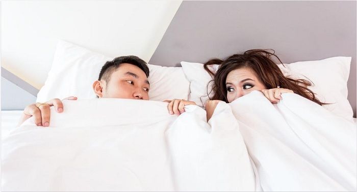 Ilustrasi pasangan pria dan wanita di atas tempat tidur