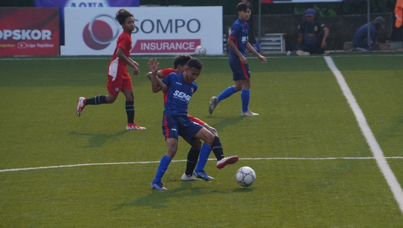 Pemain Safin Pati (merah) berusaha merebut bola dari pemain TSI Bandung pada laga terakhir penyisihan grup TopSkor Cup Nasional U-16 2022