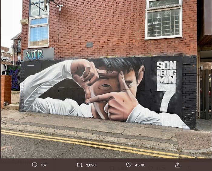 Seniman lokal Gnasher Murals melukis aksi selebrasi gol Son Heung-min di dekat stadion milik Tottenham Hotspur.