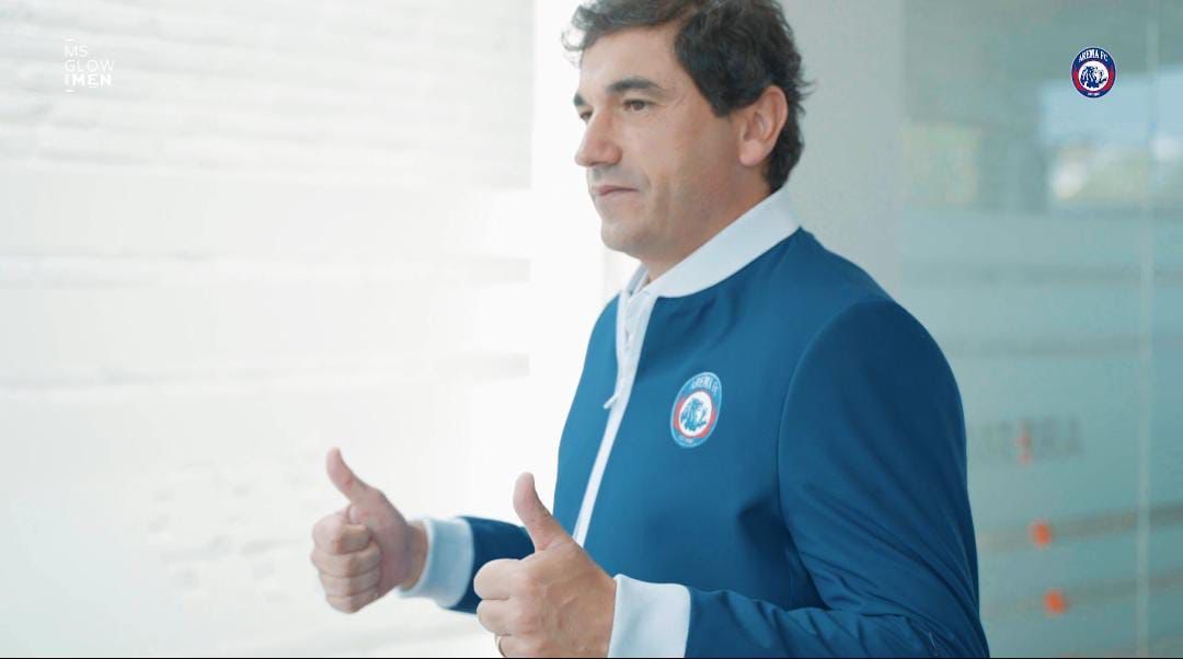 Pelatih Arema FC, Eduardo Almeida mengenakan kemeja putih dibalut jas berwarna biru yang disertai denganlogo tim