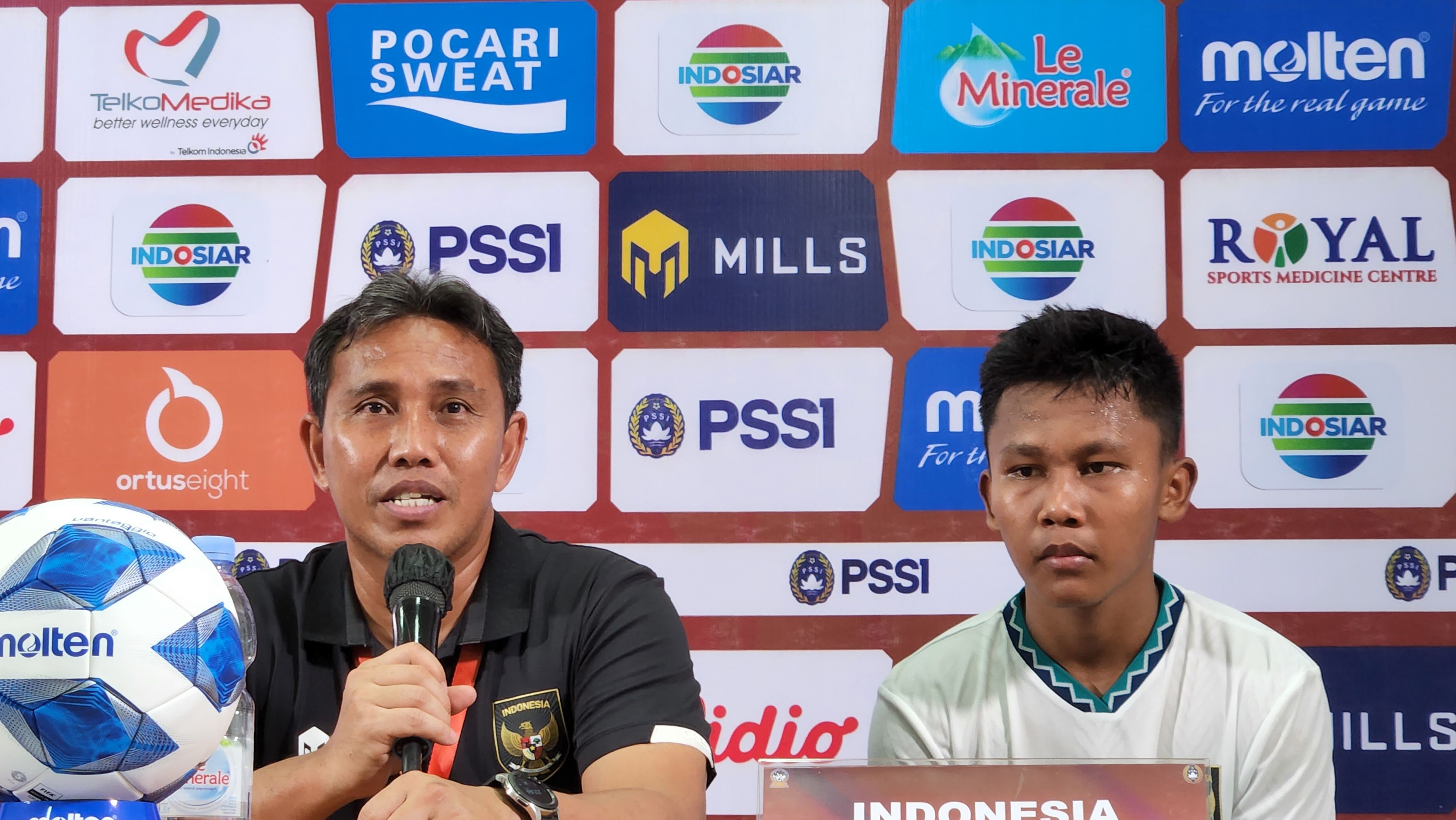 Pelatih timnas U-16 Indonesia, Bima Sakti (kiri), ditemani anak asuhnya, Muhammad Nabil Asyura, pada sesi konferensi pers seusai pertandingan lanjutan Grup A Piala AFF U-16 2022 kontra Filipina di Stadion Maguwoharjo, Sleman, Rabu (3/8/2022).
