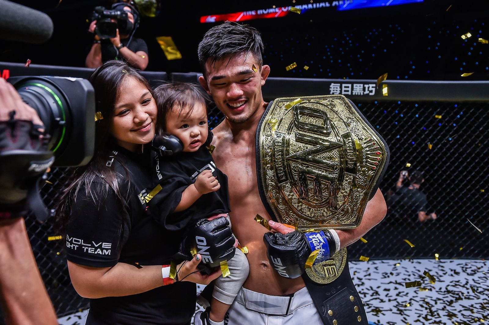 Christian Lee (kanan) merayakan keberhasilan merebut sabuk juara dunia ONE Lightweight bersama istri dan anaknya.