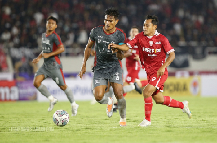 Striker Persis, Samsul Arif (merah) coba merebut bola dari bek Madura United, Fachrudin Aryanto dalam laga Liga 1 2022-2023, 23 Agustus 2022.