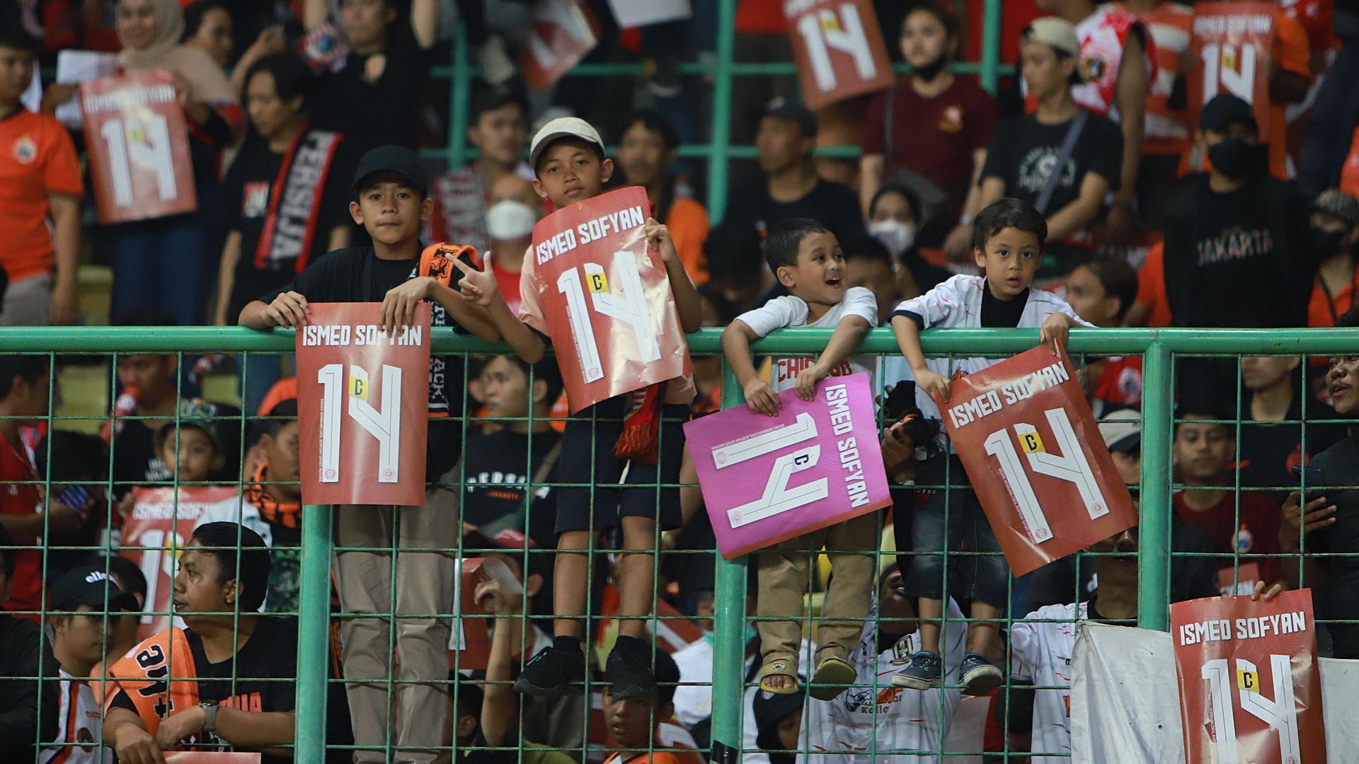 Empat suporter cilik memamerkan poster nomor punggung Ismed Sofyan saat Persija menjamu Madura United pada pekan ke-10 Liga 1 2022-2023 di Stadion Patriot Candrabagha, Bekasi, 17 September 2022.