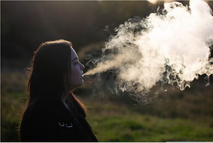 Ilustrasi seorang wanita merokok, kebiasaan yang dapat memicu terjadinya menopause dini.