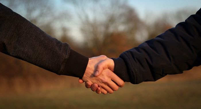 Ilustrasi dua pria saling menjabat tangan. Bahwa persahabatan antara pria tidak seemosional yang dirasakan wanita.