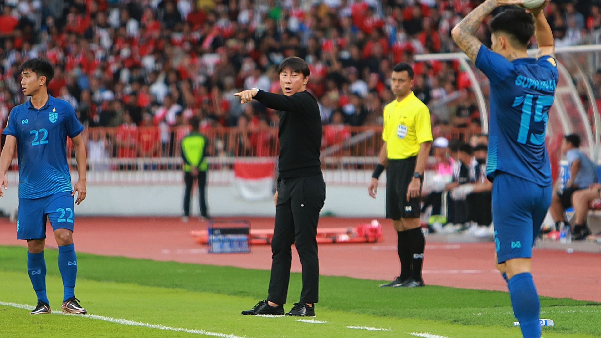 Shin Tae-yong memberi instruksi anak asuhnya di antara dua pemain lawan saat laga timnas Indonesia vs Thailand dalam laga Piala AFF 2022 di SUGBK, 29 Desember 2022.