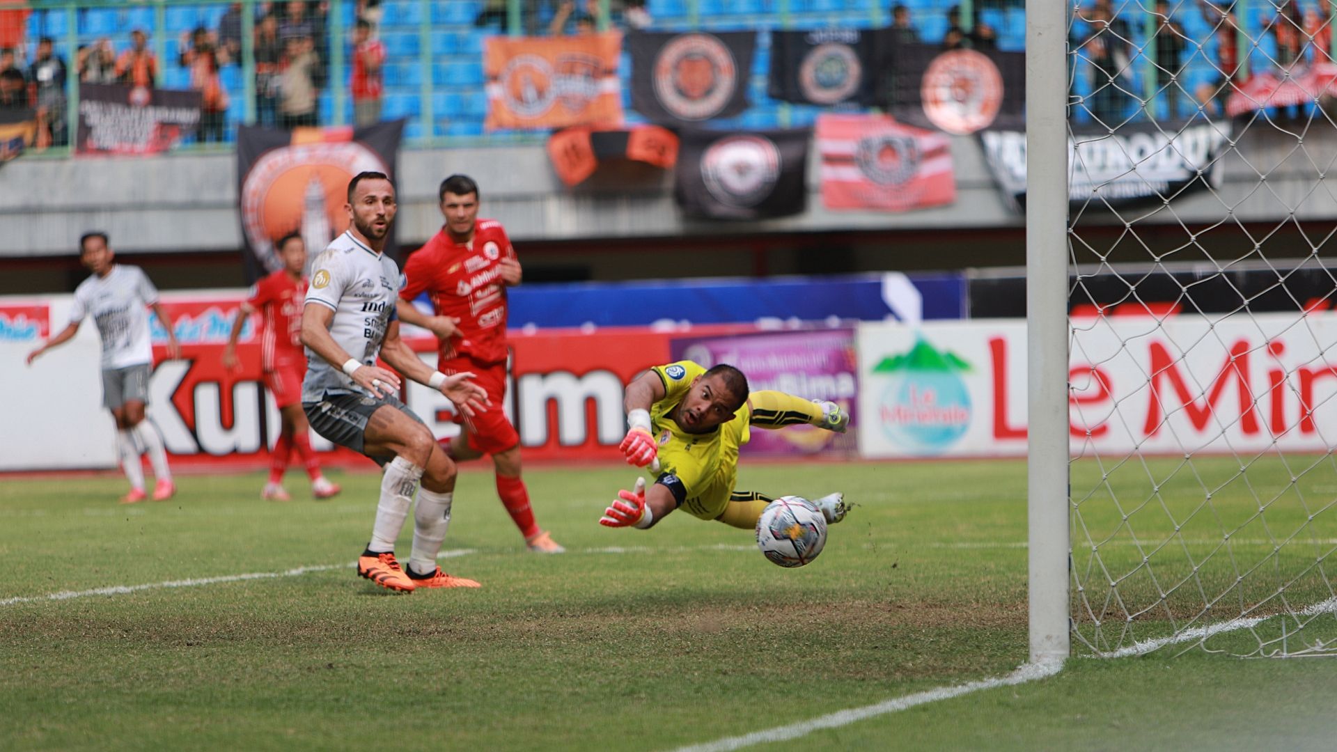 Striker Bali United, Ilija Spasojevic melihat bola yang ditendangnya masuk ke gawang Persija yang dijaga kiper Andritany (kuning) dalam laga pekan ke-18 Liga 1 2022-2023 di Stadion Patriot Candrabhaga, Kota Bekasi pada 15 Januari 2023.