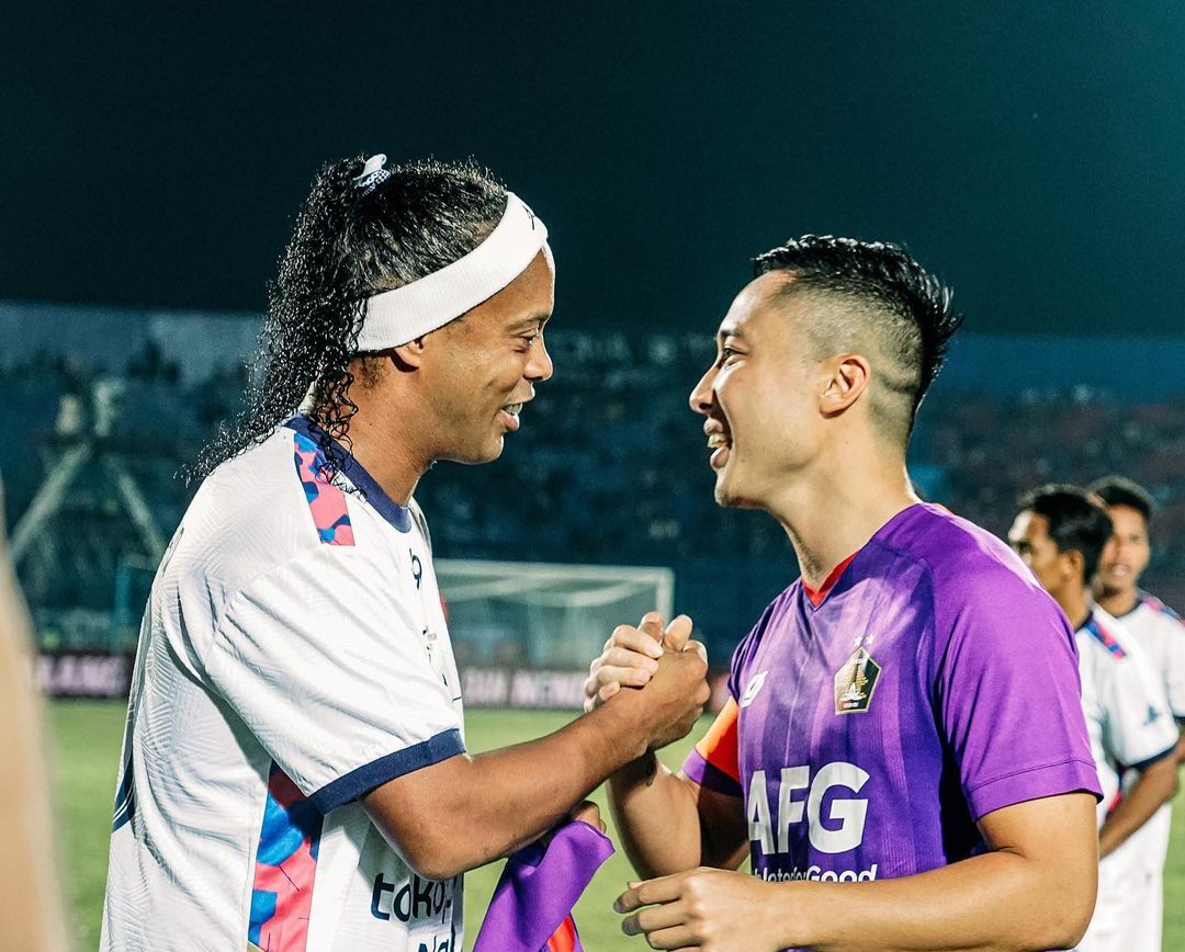 Kapten Persik, Arthur Irawan berjabat tangan dengan Ronaldinho yang bermain untuk Rans Nusantara FC dalam trofeo di Stadion Kanjuruhan, Kabupaten Malang, 26 Juni 2022.